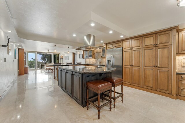 kitchen featuring a large island, hanging light fixtures, island exhaust hood, a kitchen bar, and stainless steel fridge with ice dispenser