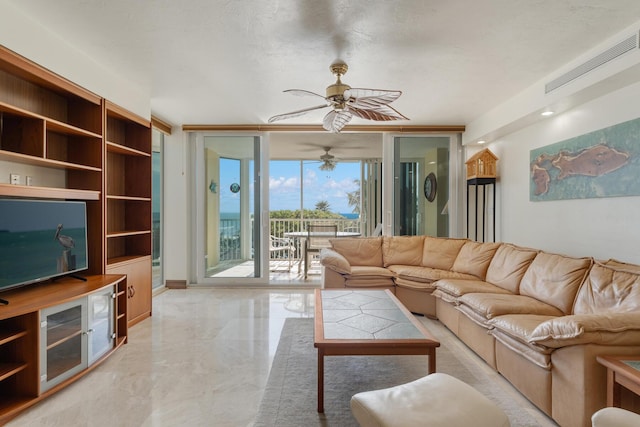 living room featuring ceiling fan and a wall of windows