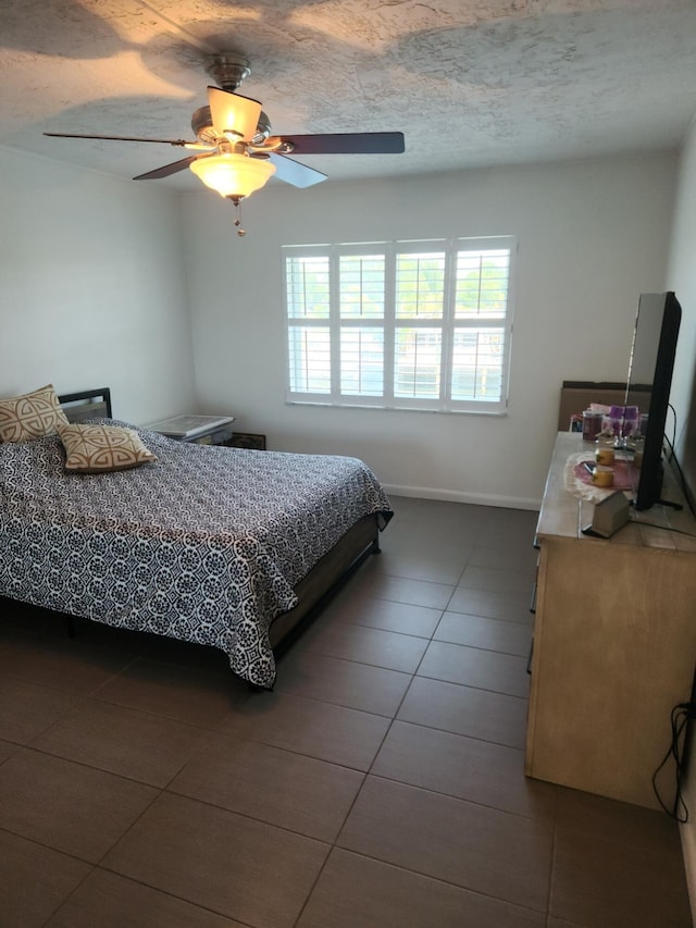 tiled bedroom with multiple windows, ceiling fan, and a textured ceiling