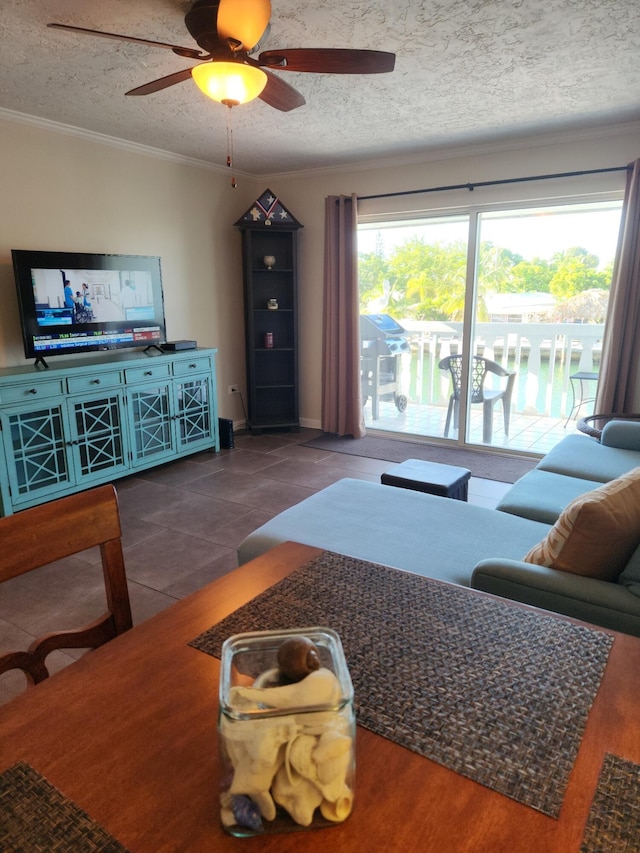 tiled living room featuring ornamental molding, ceiling fan, and a textured ceiling