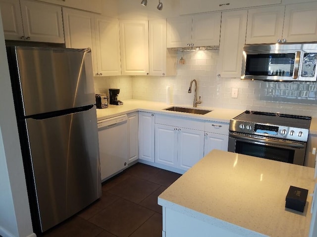 kitchen with sink, backsplash, stainless steel appliances, and white cabinets