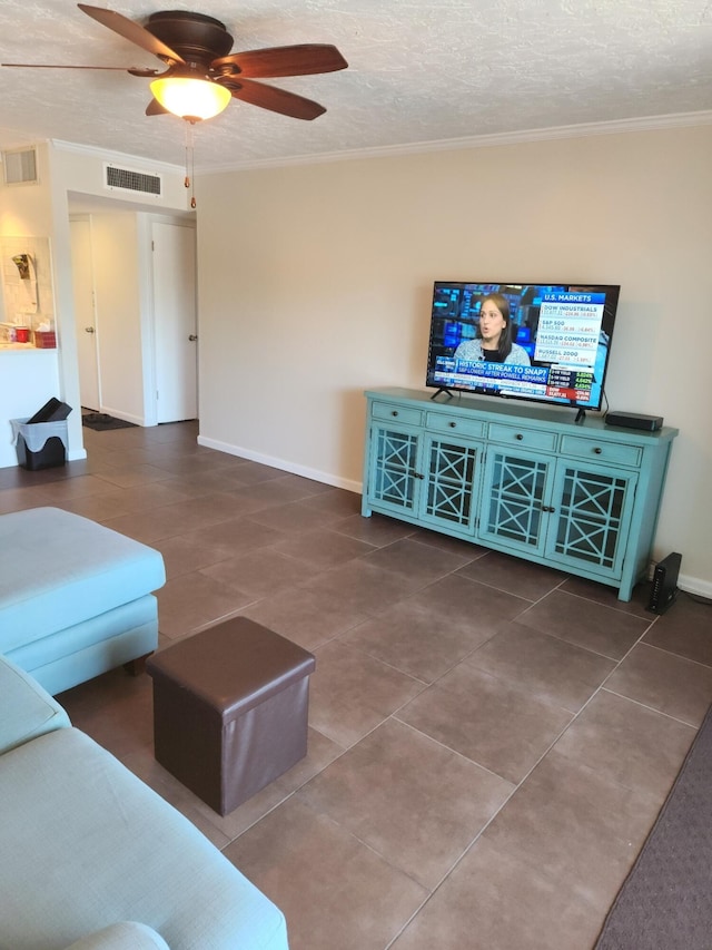 living room with crown molding, ceiling fan, a textured ceiling, and dark tile patterned floors