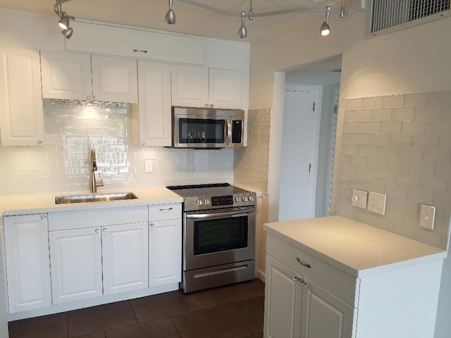 kitchen featuring sink, backsplash, stainless steel appliances, and white cabinets