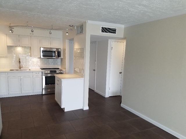 kitchen featuring sink, white cabinets, backsplash, stainless steel appliances, and a textured ceiling