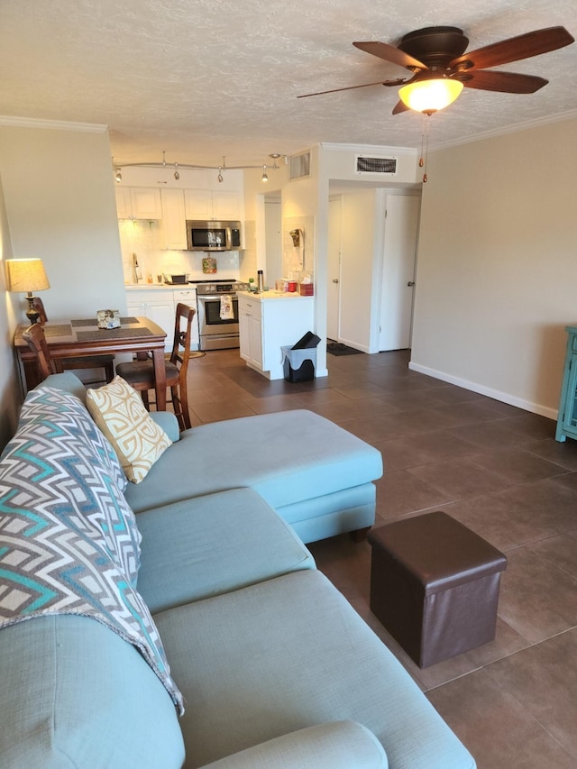 tiled living room featuring ornamental molding, ceiling fan, and a textured ceiling