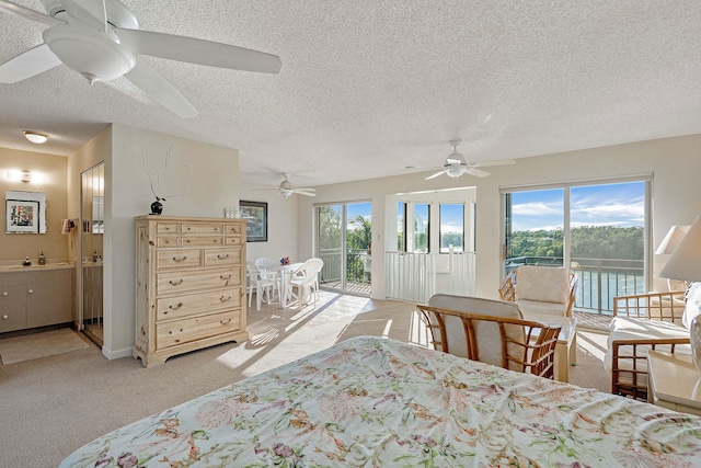 carpeted bedroom featuring multiple windows, connected bathroom, access to outside, and a water view