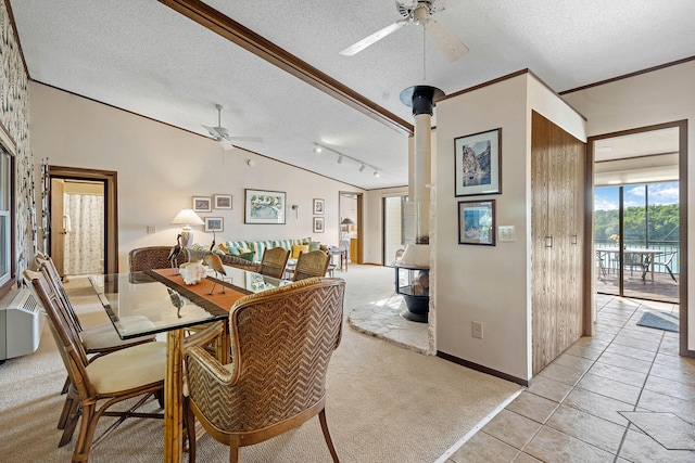 tiled dining space with ceiling fan, track lighting, ornamental molding, a textured ceiling, and vaulted ceiling