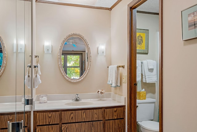 bathroom featuring crown molding, vanity, and toilet