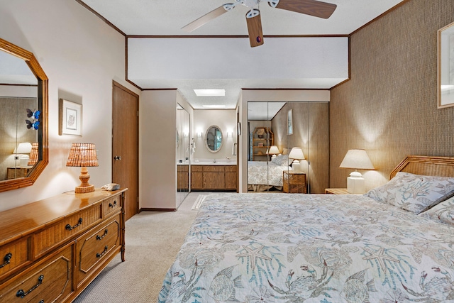 bedroom with crown molding, light colored carpet, ceiling fan, and ensuite bath