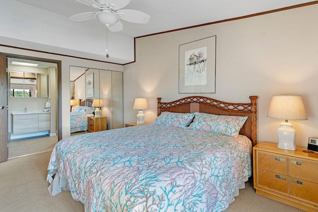 carpeted bedroom with connected bathroom, crown molding, and ceiling fan