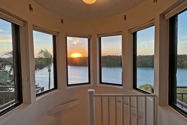 sunroom / solarium featuring a water view