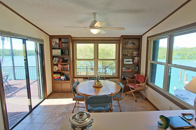 tiled dining room with crown molding, vaulted ceiling, and a water view