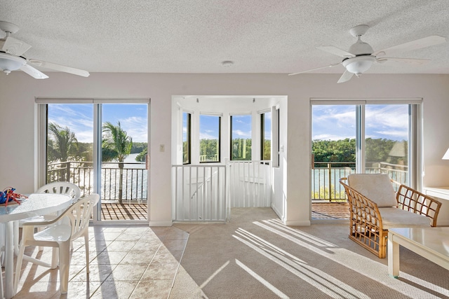 sunroom / solarium featuring a healthy amount of sunlight and ceiling fan