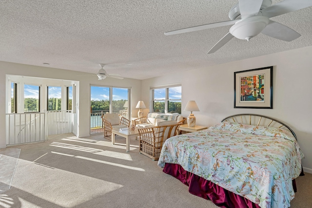 carpeted bedroom with access to outside, a textured ceiling, and ceiling fan