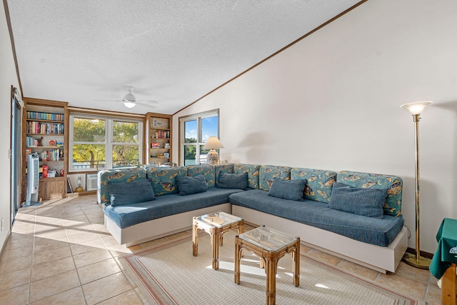 living room with ceiling fan, lofted ceiling, light tile patterned floors, and a textured ceiling