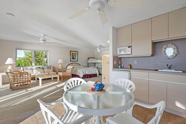 tiled dining area featuring sink, a textured ceiling, and ceiling fan