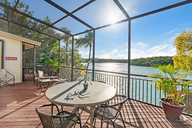 sunroom featuring a water view