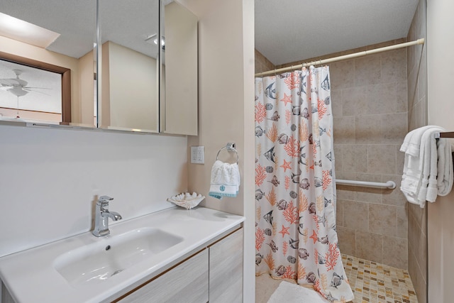 bathroom with vanity, a textured ceiling, ceiling fan, and walk in shower