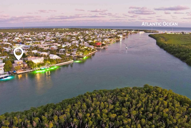 aerial view at dusk featuring a water view