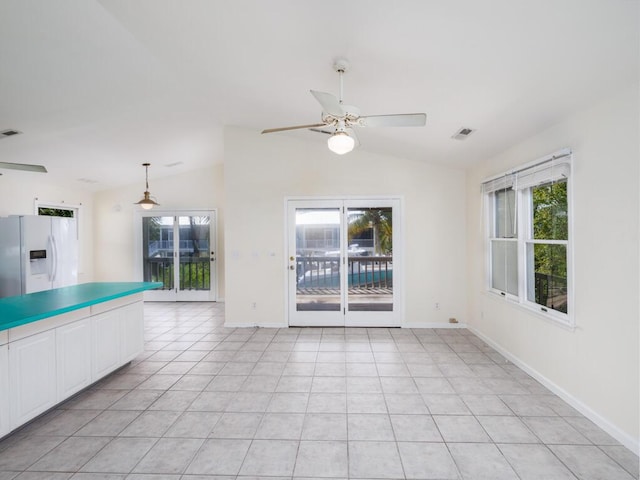 interior space featuring lofted ceiling, light tile patterned floors, and ceiling fan