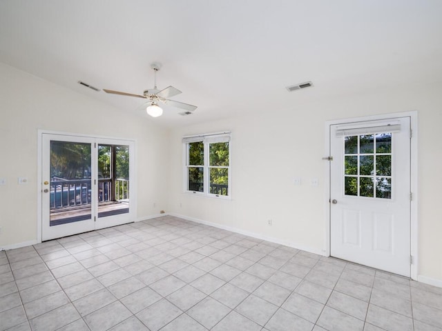 tiled spare room with vaulted ceiling and ceiling fan