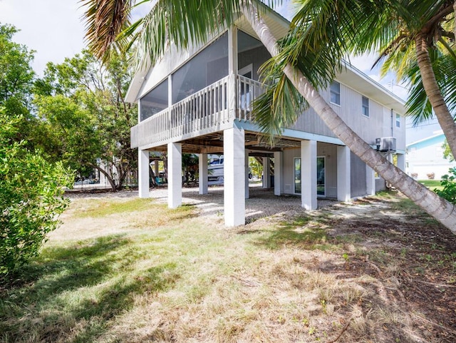 back of house with a sunroom and a lawn