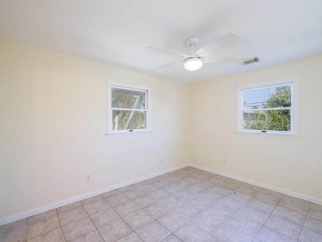 spare room featuring ceiling fan and a wealth of natural light