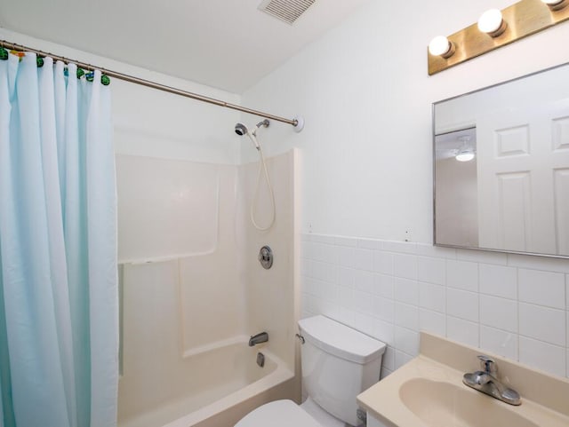 full bathroom with tile walls, vanity, shower / bath combo, and toilet