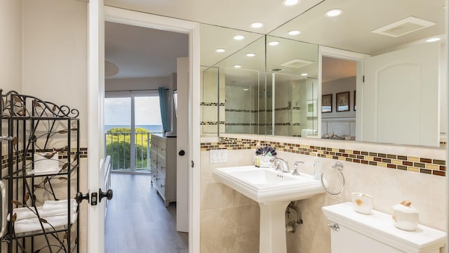 bathroom with tasteful backsplash, wood-type flooring, and toilet