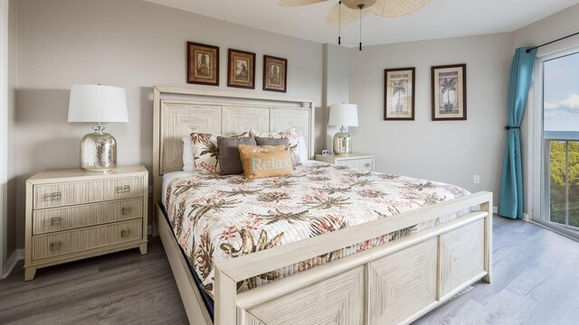 bedroom featuring access to exterior, dark hardwood / wood-style floors, and ceiling fan