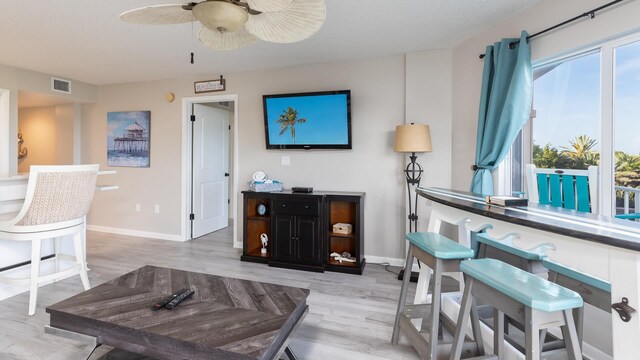 living room featuring light hardwood / wood-style floors and ceiling fan