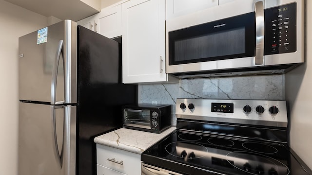 kitchen with stainless steel appliances, light stone countertops, decorative backsplash, and white cabinets