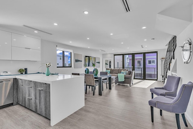 kitchen featuring white cabinets, french doors, dishwasher, and light wood-type flooring