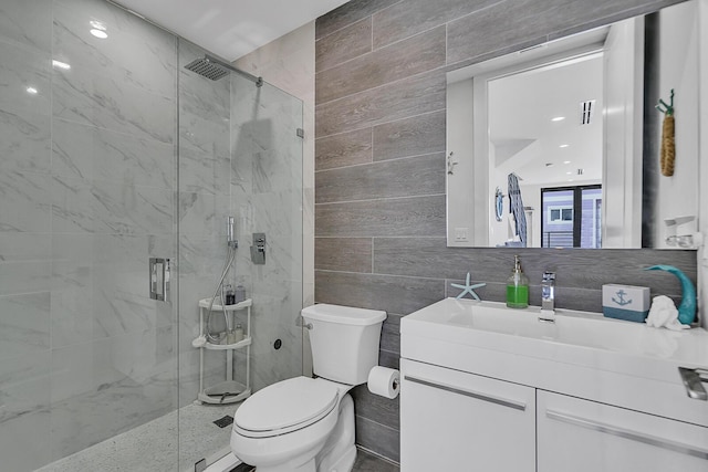 bathroom with tasteful backsplash, tile walls, vanity, walk in shower, and toilet