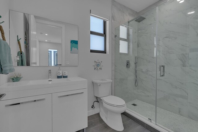 bathroom featuring vanity, toilet, and a shower with shower door