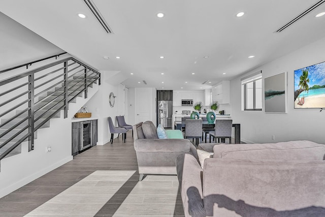 living room featuring bar and light wood-type flooring