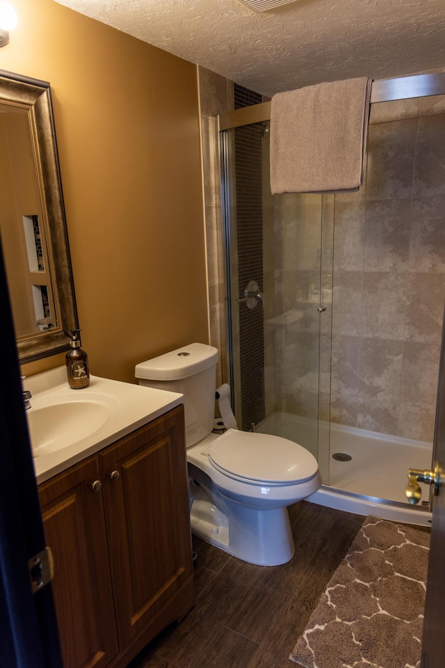 3355 Flagler Ave, Key West, FL 33040 - full bath with wood finished floors, vanity, a textured ceiling, a stall shower, and toilet