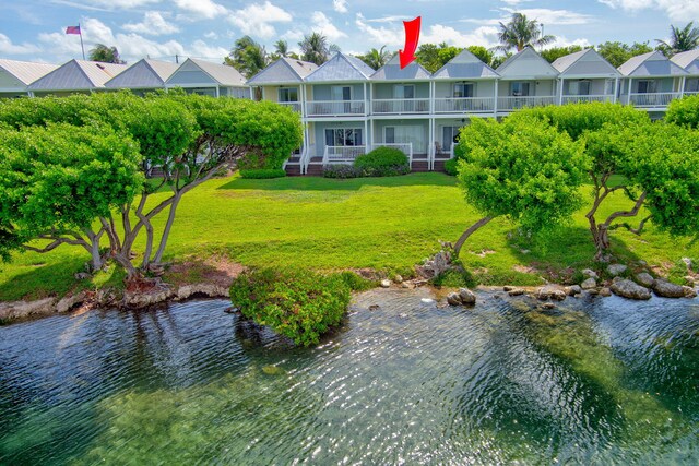 view of property's community with a yard and a water view