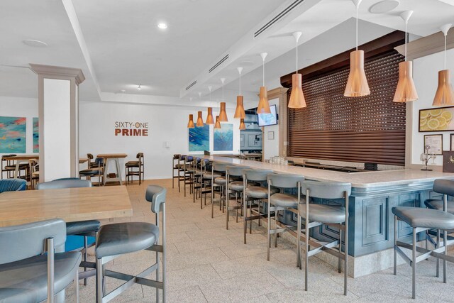 kitchen with hanging light fixtures, a kitchen bar, and kitchen peninsula