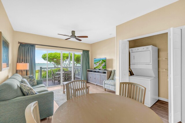 dining room featuring stacked washer / dryer, ceiling fan, and light hardwood / wood-style flooring