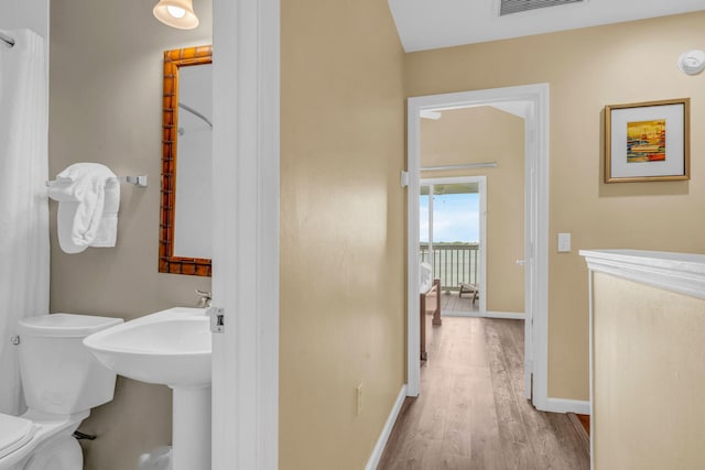 bathroom featuring hardwood / wood-style flooring and toilet