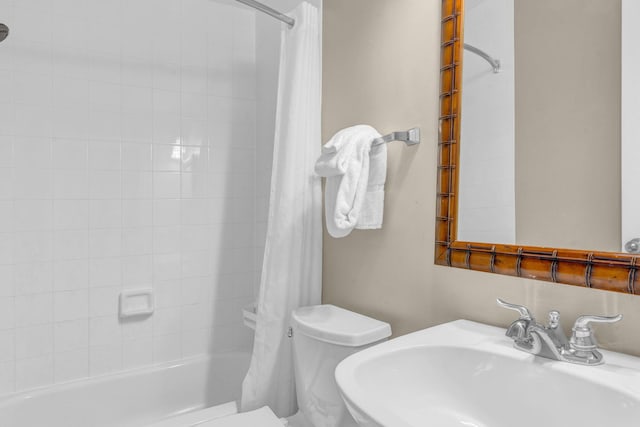 full bathroom featuring shower / tub combo with curtain, sink, and toilet