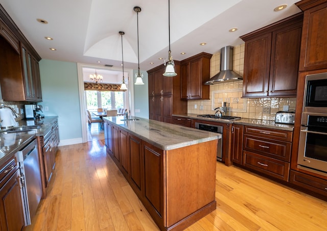 33 Cypress Ave, Key Haven, FL 33040 - kitchen featuring a center island with sink, wall chimney range hood, tasteful backsplash, light wood-type flooring, and recessed lighting
