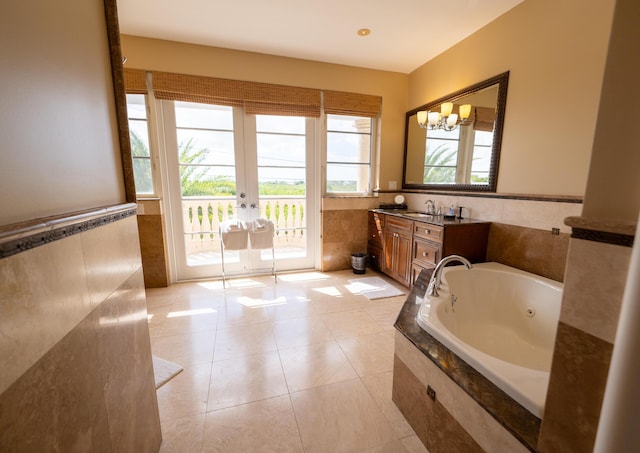 33 Cypress Ave, Key Haven, FL 33040 - full bathroom featuring a whirlpool tub, vanity, tile walls, tile patterned floors, and french doors