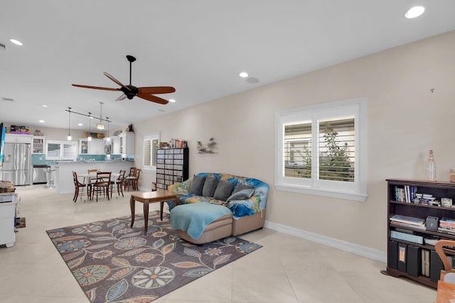 living room featuring baseboards, ceiling fan, vaulted ceiling, light tile patterned floors, and recessed lighting