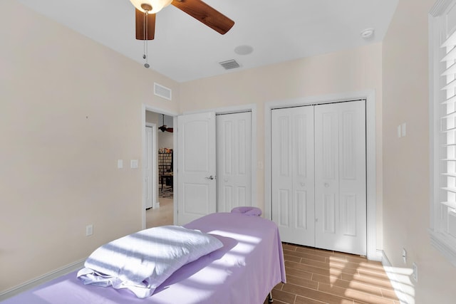 bedroom with ceiling fan, multiple closets, visible vents, and light wood-type flooring