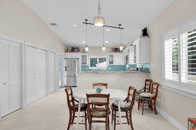 dining space with light tile patterned floors, baseboards, visible vents, recessed lighting, and vaulted ceiling