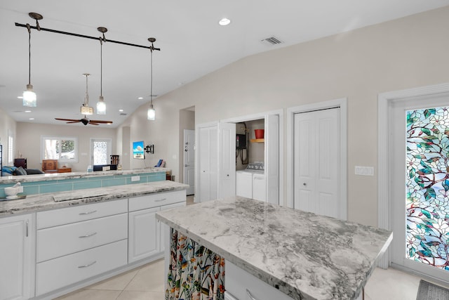 kitchen with a center island, ceiling fan, open floor plan, pendant lighting, and white cabinetry