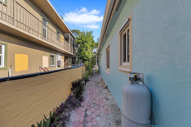 view of side of home with stucco siding and fence