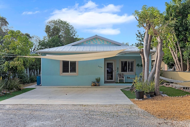 view of front of property featuring stucco siding, metal roof, and a standing seam roof